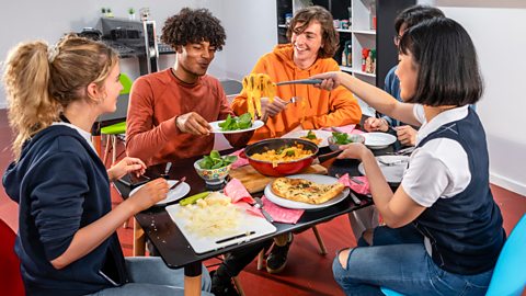 Students eating around a table together