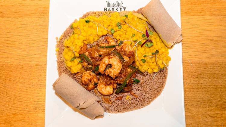A plate of shrimp tibs over injera.