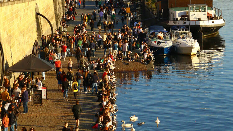 People watch and drink beers at Náplavka