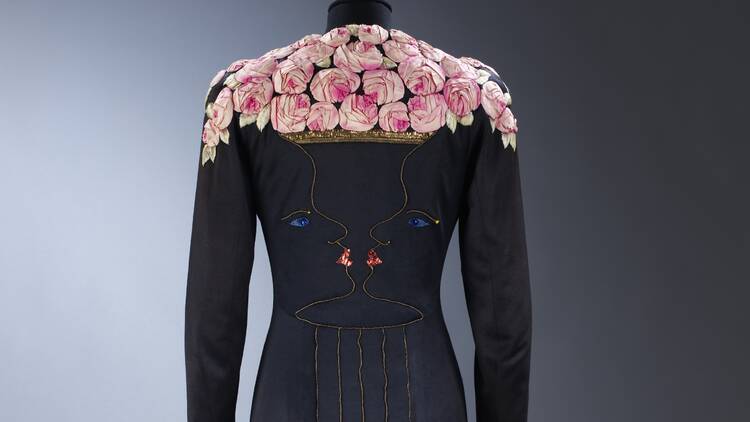 Ankle-length coat of black silk jersey with facial profiles forming a rose-filled vase,